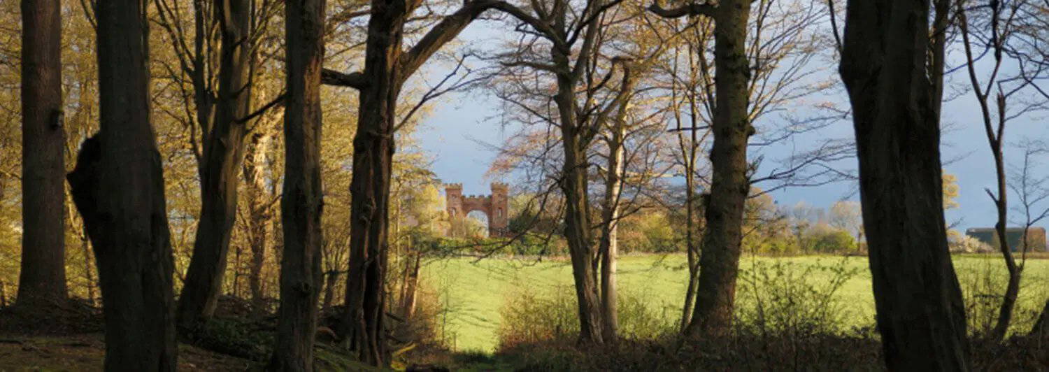 Historic folly seen through parkland trees